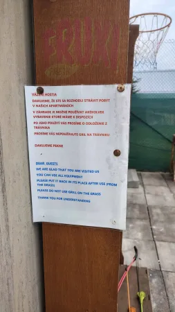 Informační cedule na dveřích s pravidly užívání zahrady a vybavení