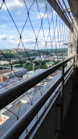 Výhled ze střechy Baťova mrakodrapu skrze ocelovou záchrannou síť na město