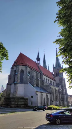 Boční pohled na kostel Nanebevzetí Panny Marie v Chrudimi s červenou střechou