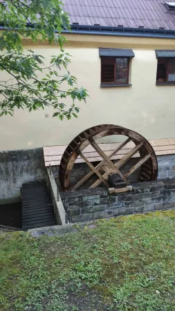 Dřevěné vodní kolo Starého mlýna v Chrudimi u žluté budovy s hnědými okny