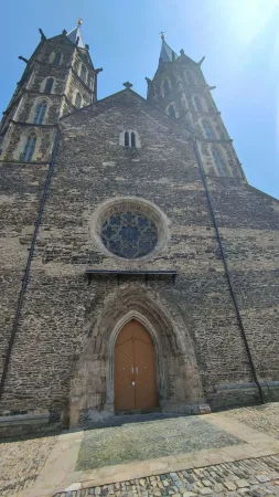 Průčelí gotického chrámu svatého Bartoloměje v Kolíně s růžicovým oknem a dvěma věžemi