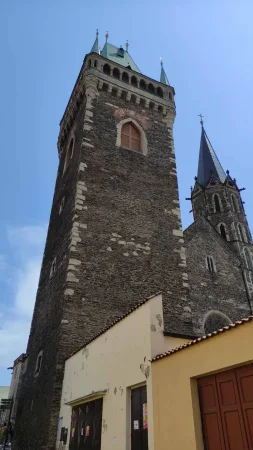 Kamenná gotická zvonice u chrámu svatého Bartoloměje v Kolíně pod modrou oblohou