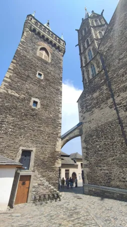Kamenná zvonice a chrám svatého Bartoloměje spojené gotickým obloukem v Kolíně
