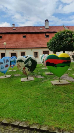 Barevná srdce Srdce Evropy na trávníku před červenou střechou zámku v Poděbradech