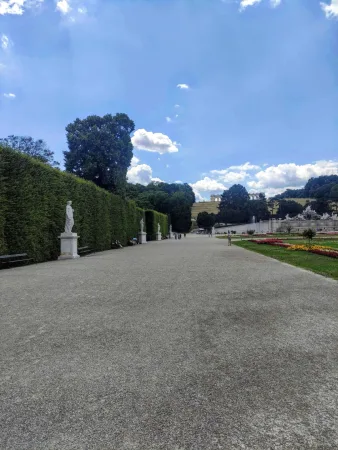 Upravená alej v zámecké zahradě Schönbrunn s výhledem na Gloriette