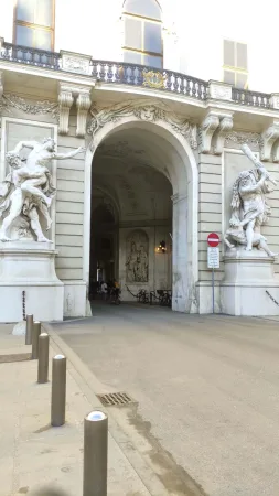Klenutá brána Michaelertor se sochami herkulovských zápasů