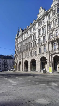 Honosná historická budova na rohu vídeňské ulice s podloubím