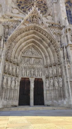 Dřevěné vstupní dveře kostela Votivkirche zdobené sochami svatých