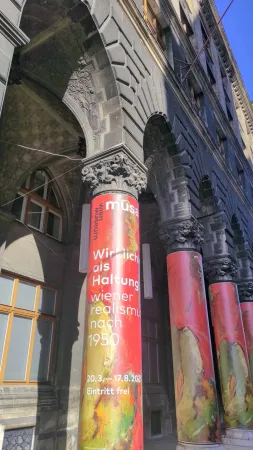 Barevné výstavní bannery na sloupech podloubí vídeňského muzea