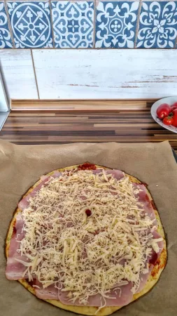 Cuketová pizza se šunkou a sýrem na kuchyňské lince