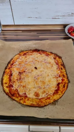 Upečená cuketová pizza se zlatavým zapečeným sýrem na plechu s pečicím papírem