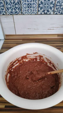 Hotové čokoládové těsto na cuketovou bábovku rozmíchané v bílé míse s vařečkou.