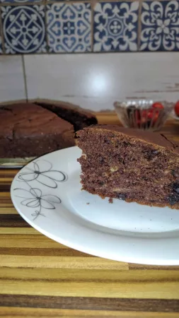 Plátek cuketového koláče na talíři vedle zbytku upečeného koláče.