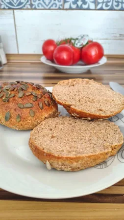 Celá bulka a nakrájené plátky pečiva se špaldou a tvarohem