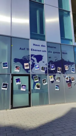 Vstup do Haus des Meeres s mapou světa a fotkami zvířat na skle