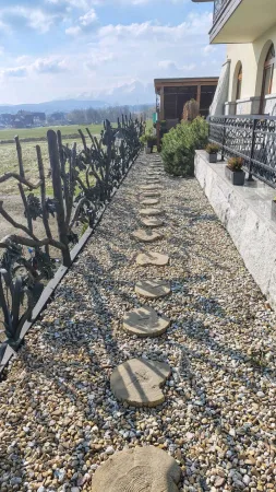 Kamenný chodník v zahradě hotelu Gorski s výhledem na Tatry