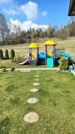 Barevné dětské hřiště na trávníku v zahradě hotelu Gorski