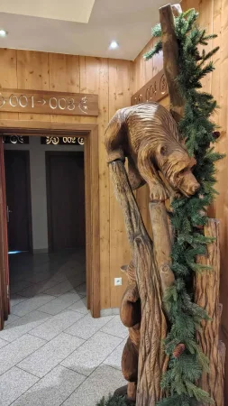 Dřevěná řezba medvěda v chodbě hotelu Gorski s čísly pokojů