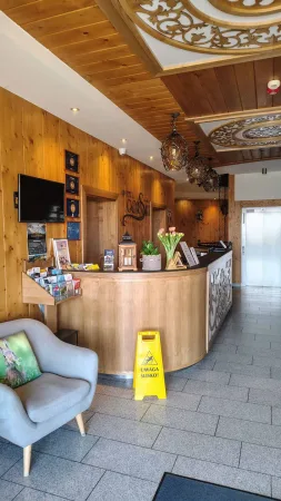 Recepční pult hotelu Gorski s tulipány a brožurami na pultu