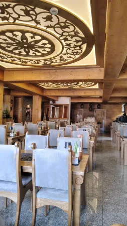 Elegantní restaurace hotelu Gorski s ozdobnými dřevěnými dekoracemi na stropě