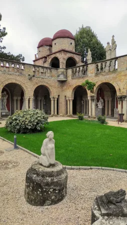 Travnaté nádvoří hradu Bory vár obklopené arkádami, kopulemi a sochou