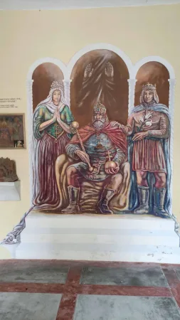 Nástěnná malba krále na trůnu obklopeného královnou a princem