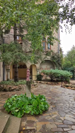 Nádvoří hradu Bory vár se stromem, sochou na sloupu a freskou