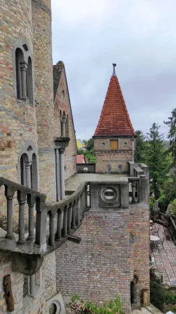 Pohled z balkonu na hradní věž s červenou kuželovou střechou