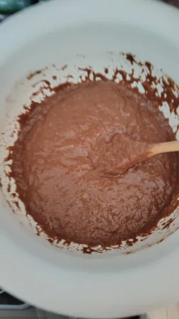 Míchání kakaového těsta na perník v míse s dřevěnou vařečkou