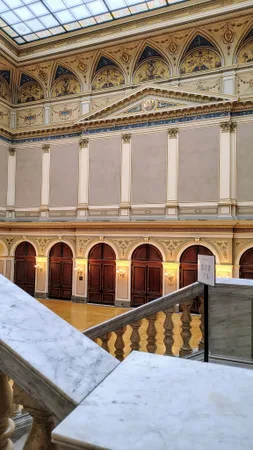 Hlavní sál Rudolfina s ozdobnou balustrádou a zdobenou klenbou stropu