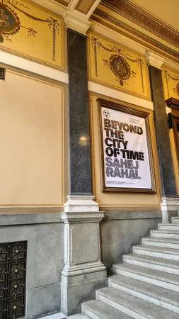 Plakát výstavy Beyond the City of Time od Sahej Rahala na zdobené stěně budovy
