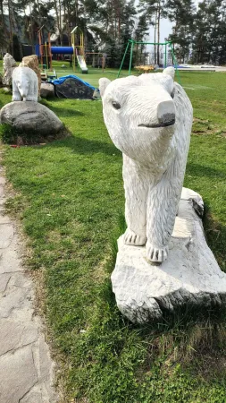 놀이터 옆 잔디밭에 놓인 북극곰 조각상