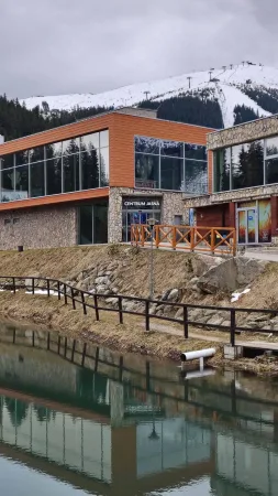 Budova Centrum Jasná u Vrbického plesa s výhledem na zasněžený sjezdový svah