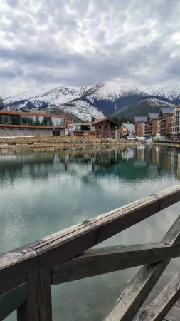 Jezero s odrazem hor a přilehlých budov z dřevěného mola