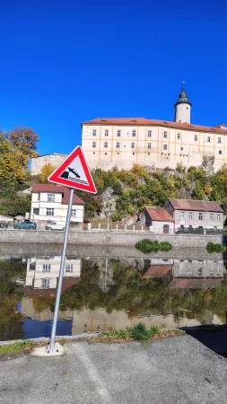Die Burg von Ledeč über der Sázava mit einem Warnschild im Vordergrund und klarblauem Himmel
