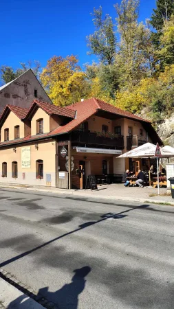 Pension mit Restaurant und Gastgarten unter dem Felsen und herbstlichen Bäumen in Ledeč nad Sázavou