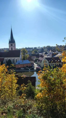 Aussicht vom Hügel auf die Dächer von Ledeč nad Sázavou mit Kirchturm und herbstlichem Grün