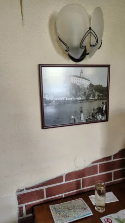 Historische Schwarz-Weiß-Fotografie der Burg über der Sázava an der Restaurantwand unter einer Lampe