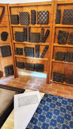Detail vyřezávaných dřevěných forem na tisk látek v regálu