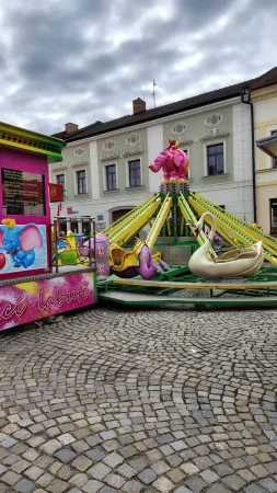 Dětský kolotoč s růžovým slonem a labutěmi na pouti