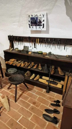 Historická obuvnická dílna s kopyty a nástroji na zdi
