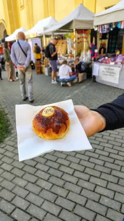 Polenský mrkvanec v ruce na pozadí jarmarku a kostela