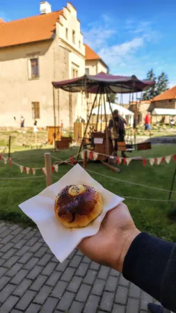 Polenský mrkvanec v ruce na pozadí zámku a poutních atrakcí