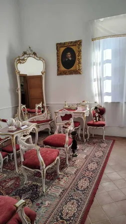Salonek se zrcadlem a čalouněnými červenými židlemi