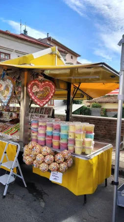 Žlutý stánek s barevnou cukrovou vatou a perníkovými srdci