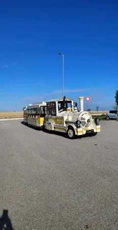 Detailní pohled na žlutý turistický vláček s lokomotivou na silnici