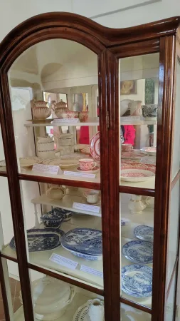 Vitrína plná starožitného porcelánu s barevnými vzory