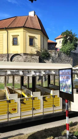 Vagóny turistického vláčku u zastávky před zámkem v Polné