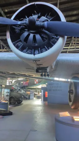 Detailní záběr na hvězdicový motor a vrtuli historického letadla v hangáru muzea.