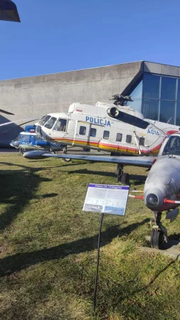 Velký policejní vrtulník Mi-8 s nápisem Policja vystavený mezi dalšími vrtulníky v muzeu.